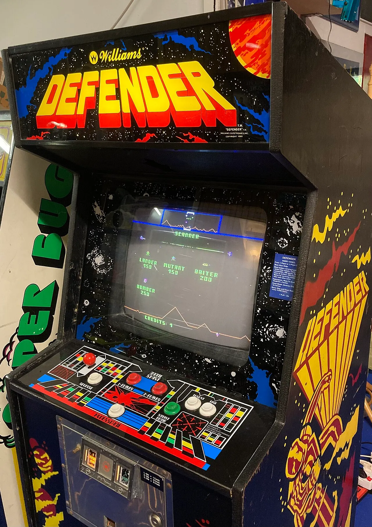 A restored Williams Defender upright arcade cabinet in attract mode.